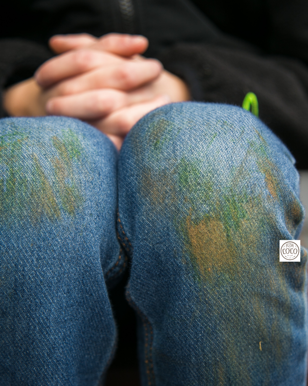 Rodillas de un pantalón de mezclilla infantil con manchas de pasto