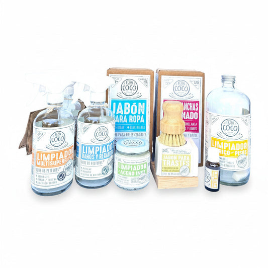 Flor de Coco CLEAN LIVING kit with natural cleaning products for laundry, dishes, bathrooms, and floors. Includes bottles, jars, and a brush.